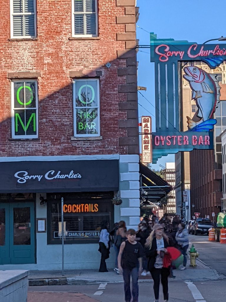 Historic brick storefronts and neon signs on a downtown Savannah, Georgia street